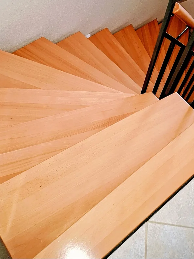 Frisch gereinigte Holztreppe mit Buchenstufen und Metallgeländer